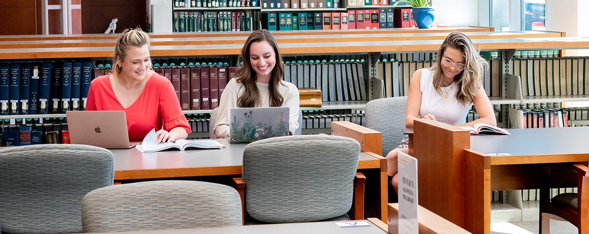 Three students studying in the library