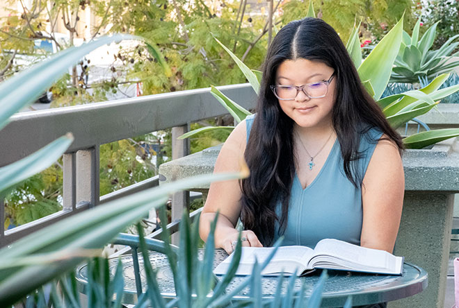 Female student studying in campus courtyard