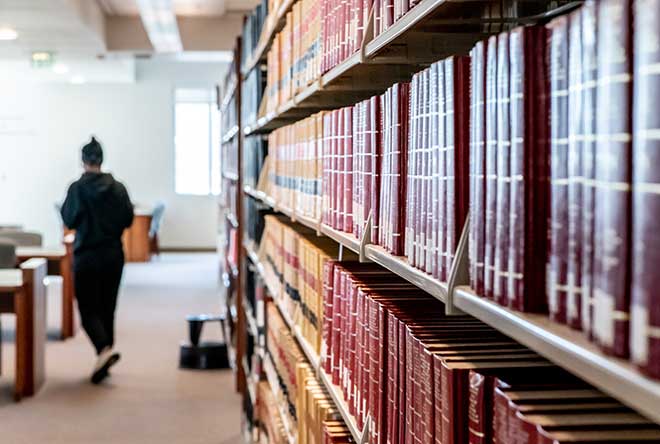 student walking away from library stacks