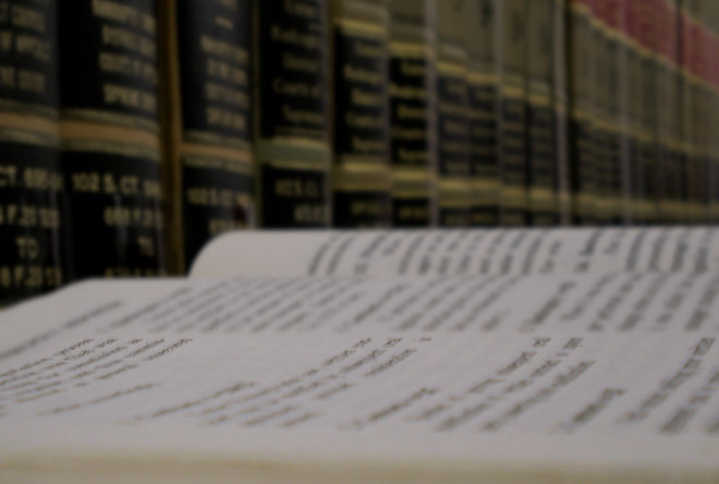 Close up of open book in front of library stacks