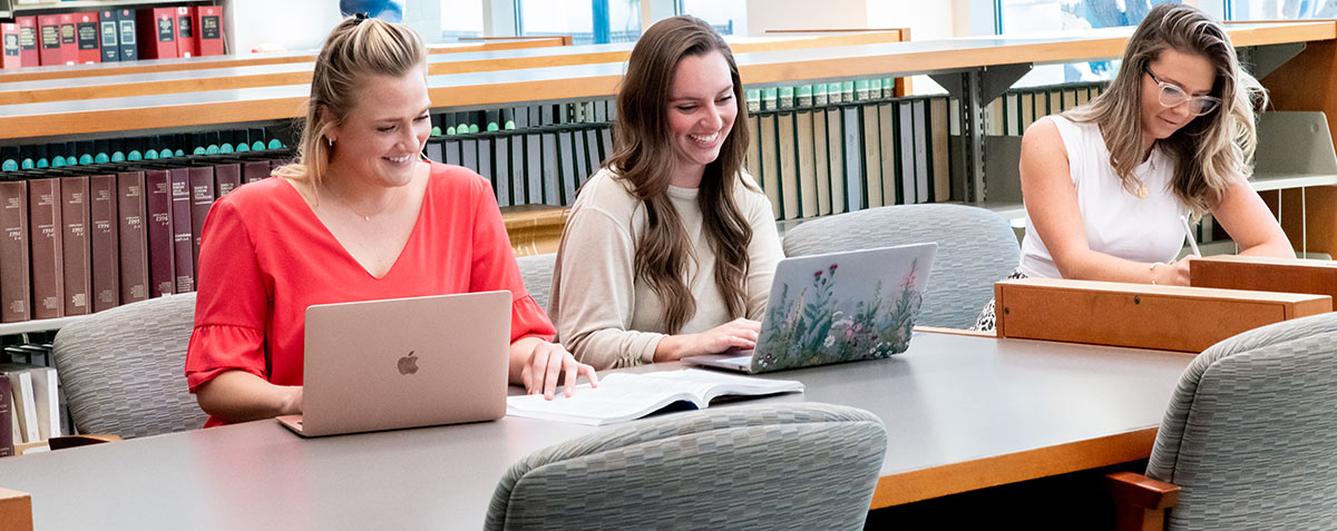 three female students studying in the library