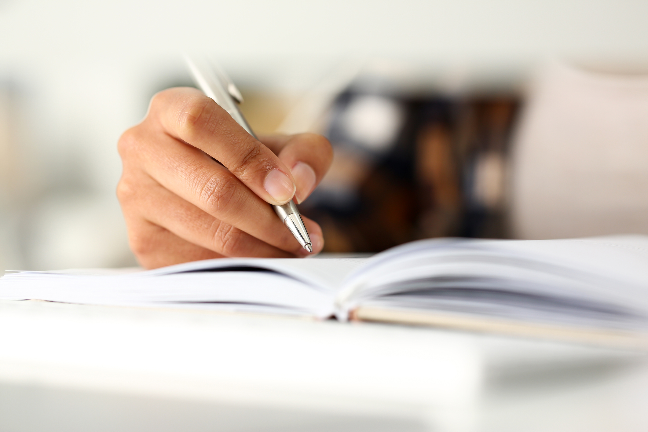 Person taking notes from book