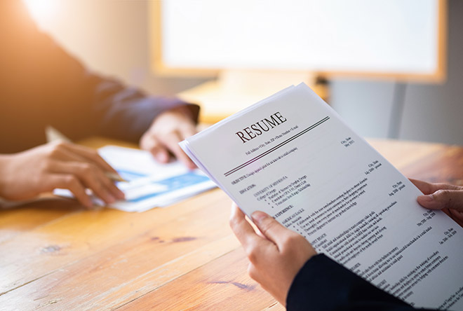 magnifying glass over chalk outlines of people for job search