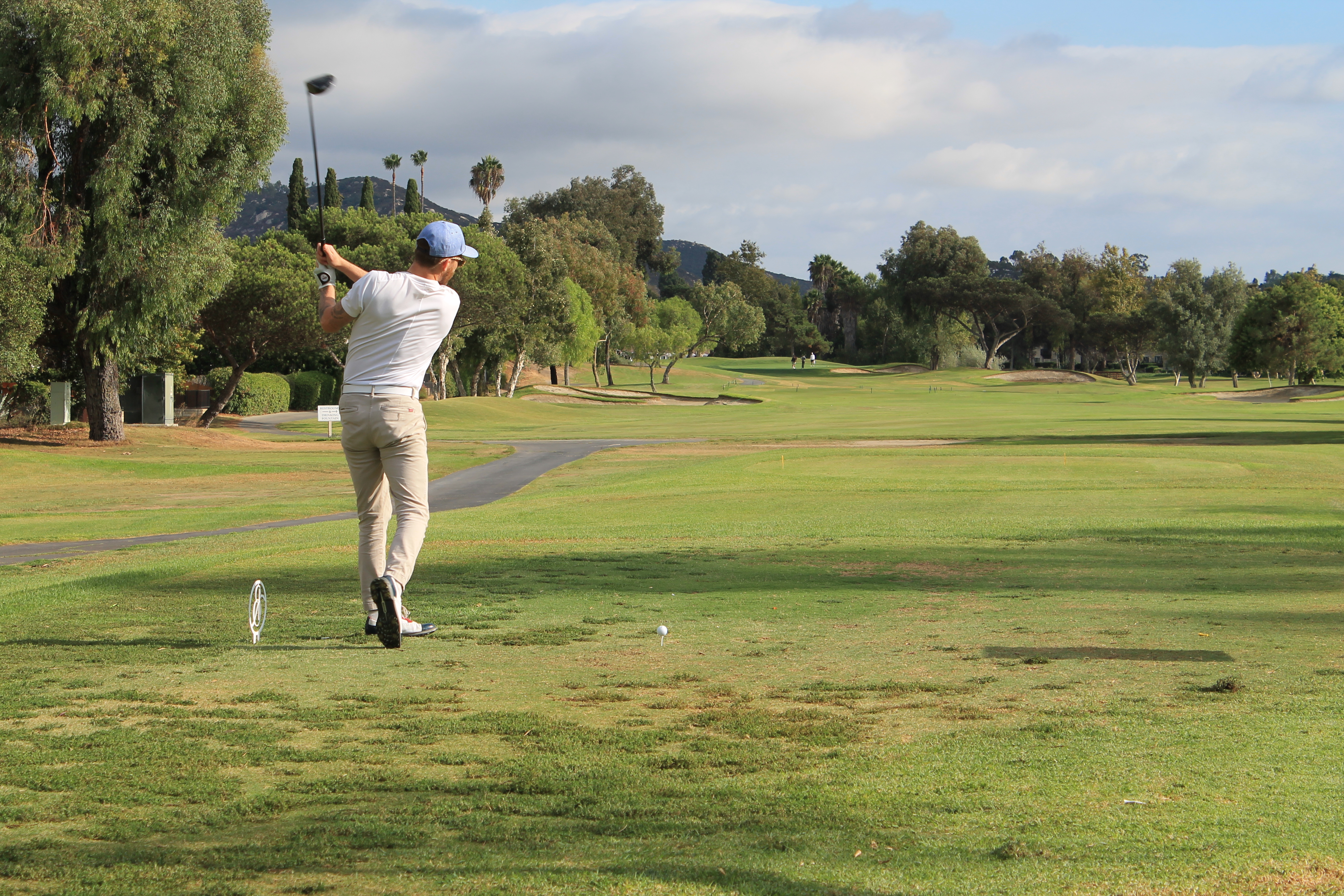 A golfer practices his swing before teeing off.