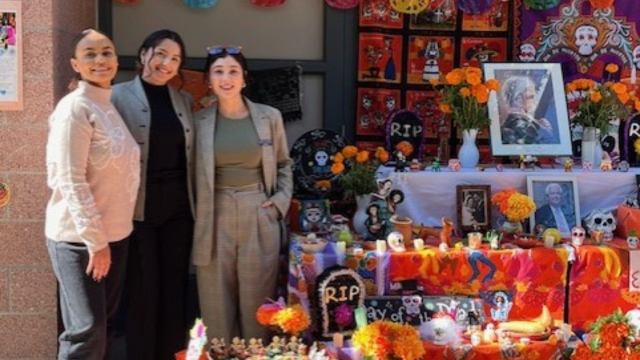 CLP Student clinicians stand next to an ofrenda at the Rosa Parks Elementary School clinic site.