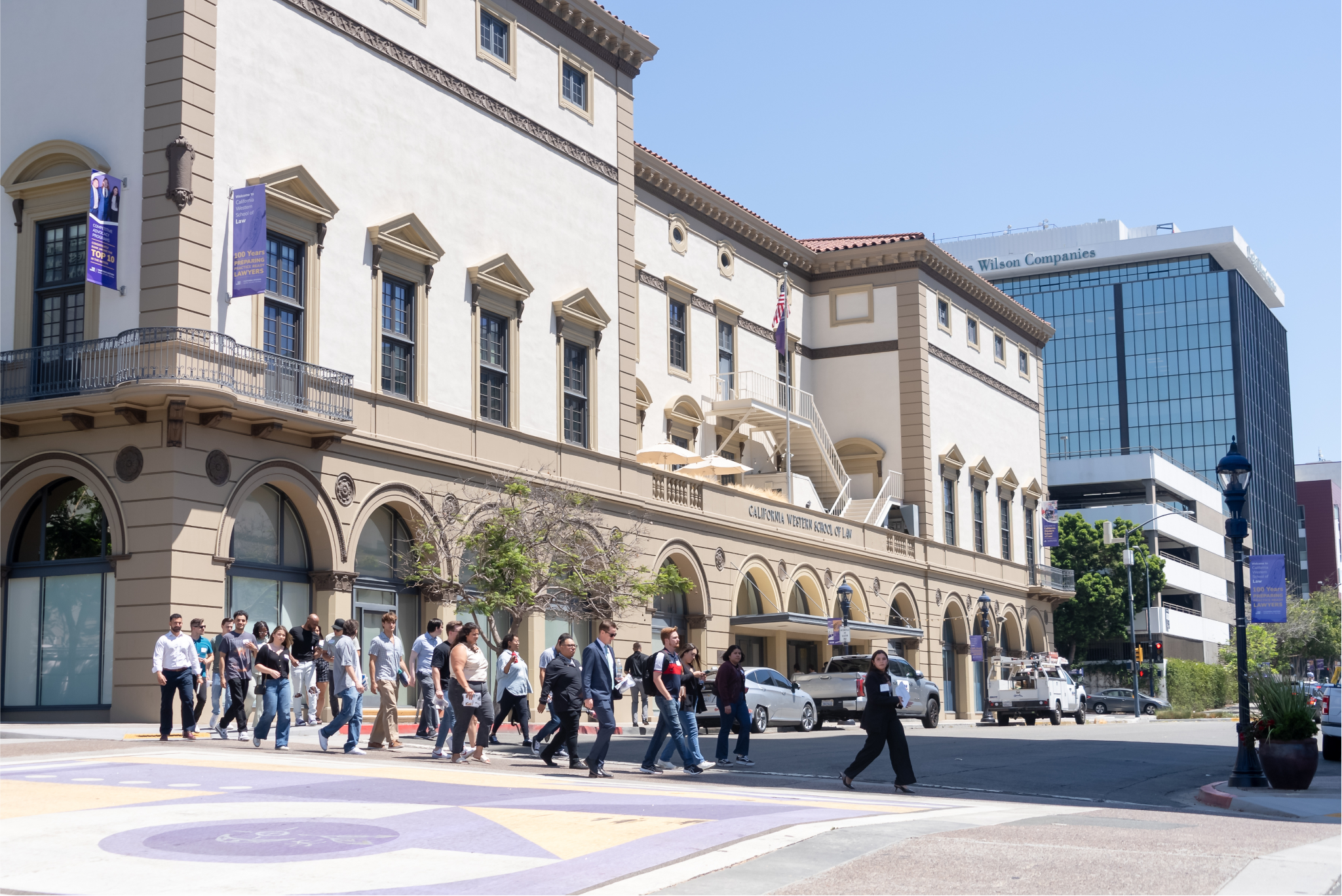 A group of students crosses the road in front of CWSL during orientation.