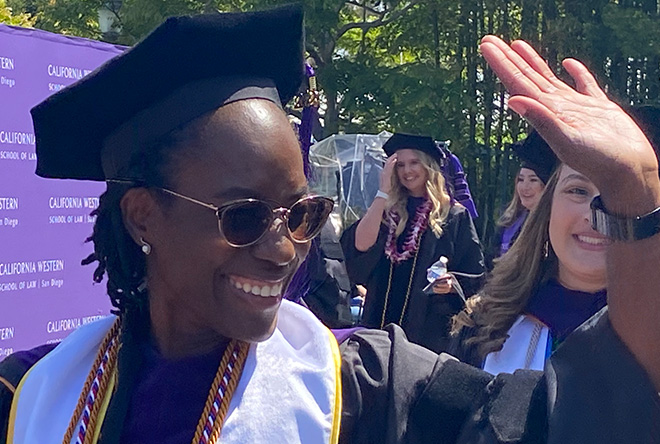 California Western School of Law student waving in celebration at commencement ceeremony